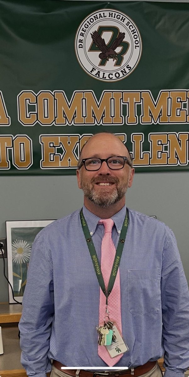 Mr. Demers standing in front of a DR sign